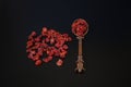 Organic anardana or sun dried seeds of pomegranate fruit on black background in vintage cooper oriental design spoon.Organic herbs