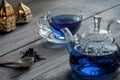 Organic Anchan blue tea, Clitoria, Butterfly tea in a glass teapot and a cup on an old wooden table, dry clitoria petals Royalty Free Stock Photo