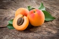 Organic apricots with leaves on wooden background Royalty Free Stock Photo