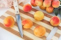 Organic apricots lying on a cutting board with a kitchen knife