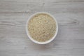 Organic Arborio rice in a white bowl on a white wooden background, top view. Flat lay, overhead, from above Royalty Free Stock Photo