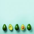 Organic avocado with seed, avocado halves and whole fruits on blue background. Top view. Square crop. Pop art design