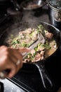 Pork and Bok Choy cooking in a frying pan on a stove Royalty Free Stock Photo
