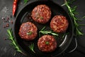 Organic beef hamburger patties with spices in a frying pan. Top view