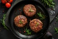 Organic beef hamburger patties with spices in a frying pan. Top view