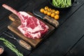 Organic beef meat raw steak,Tomahawk cut, on black wooden table , with copy space for text Royalty Free Stock Photo