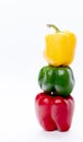 Three colorful bell peppers stacked with a white background