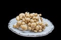 Organic brown clamshell gormet mushrooms isolated on black - sitting on fine china dish with silver trim - Selective focus