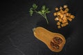 organic butternut squash with spices and ingredients for making on a black slate Royalty Free Stock Photo