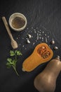 organic butternut squash with spices and ingredients for making on a black slate Royalty Free Stock Photo