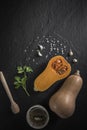 organic butternut squash with spices and ingredients for making on a black slate Royalty Free Stock Photo