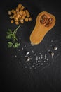 organic butternut squash with spices and ingredients for making on a black slate Royalty Free Stock Photo