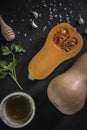 organic butternut squash with spices and ingredients for making on a black slate Royalty Free Stock Photo