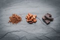 Organic cacao beans, cacao powder and chocolate on a black stone background Royalty Free Stock Photo