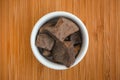 Organic Cacao Paste in a bowl on a wooden background