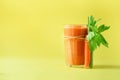 Organic carrot juice with carrots, celery on yellow background. Fresh vegetable smothie in glass. Copy space. Summer Royalty Free Stock Photo