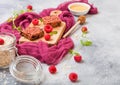 Organic cereal fruit granola bar with berries on vintage board with honey spoon and jar of oats on purple cloth. Strawberry, Royalty Free Stock Photo