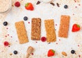 Organic cereal granola bar with berries with honey spoon and jar of oats on marble background. Top view. Strawberry, raspberry and