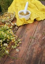 Organic chamomile flowers in porcelain pestle