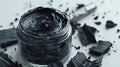 organic charcoal face mask in a jar with activated charcoal pieces on white background Royalty Free Stock Photo