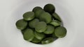 Spirulina,chlorella supplement pills on white. Selective focus