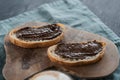 Organic chocolate hazelnut spread on ciabatta slices on wood board