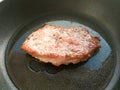 Organic cooked fried pork chop steak meat with solt, pepper, rosemary and oil on black frying pan background Royalty Free Stock Photo