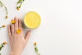 Organic cosmetic concept. Flowers of calendula, female hand and cosmetic cream isolated, on white background Royalty Free Stock Photo