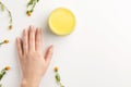 Organic cosmetic concept. Flowers of calendula, female hand and cosmetic cream isolated, on white background Royalty Free Stock Photo