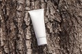 Organic cosmetic cream in tube on a tree bark natural background. Beauty product packaging mockup. Cream bottle, lotion