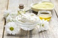 Organic cosmetics with camomile extract on wooden table background Royalty Free Stock Photo