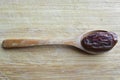 Organic dried hurma dates medjool grains, in wooden spoon on cutting board