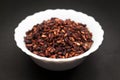 Organic Dried Pomegranate seeds in ceramic bowl.