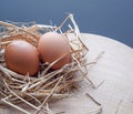 Organic eggs resting in hay sits on a Chopping Wood Royalty Free Stock Photo