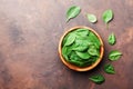 Organic food. Baby spinach leaves in wooden bowl on rustic stone table top view. Copy space for text. Royalty Free Stock Photo
