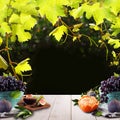 Organic food background with fruits, green grape leaves and white wooden table