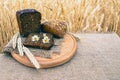 Organic food - bread lying on the table, against the background of a wheat field. Agricultural with food background Royalty Free Stock Photo