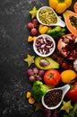Organic food. Fruits, vegetables, beans and nuts on a black stone background. Top view. Royalty Free Stock Photo