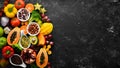 Organic food. Fruits, vegetables, beans and nuts on a black stone background. Top view.