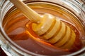 Organic food and healthy diet concept with a macro close up on a wood honey dipper or drizzler pouring aromatic honey into a glass