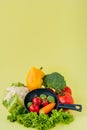 Organic food. Healthy vegetables with broccoli, lettuce, red and yellow sweet pepper, cucumber on a black skillet. Top view. Vegan Royalty Free Stock Photo