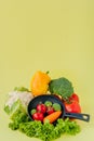 Organic food. Healthy vegetables with broccoli, lettuce, red and yellow sweet pepper, cucumber on a black skillet. Top view. Vegan Royalty Free Stock Photo