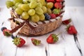 Organic fresh berries of green grapes, strawberries, raspberries, blue blueberries in a basket on a dark concrete background. Royalty Free Stock Photo