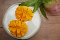 Organic fresh mango fruit with leaves and juicy slices mango on a plate on a wooden background. Healthy food menu tropical Royalty Free Stock Photo