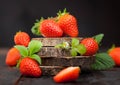 Organic fresh raw strawberries with leaf on timber round boards on dark background Royalty Free Stock Photo