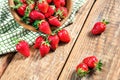 Organic fresh ripe strawberry on an old vintage wooden table. Berries are poured from a wooden bowl on a background.