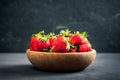 Organic fresh ripe strawberry in a wooden bowl on a dark background. Healthy fruits and berry, vegaterian food Royalty Free Stock Photo
