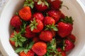 Organic fresh strawberries lying in a white bowl