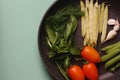 Organic fresh vegetables courgette, tomato, asparagus, basil, dill, green peas, garlic in a frying pan Royalty Free Stock Photo