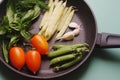 Organic fresh vegetables courgette, tomato, asparagus, basil, dill, green peas, garlic in a frying pan Royalty Free Stock Photo